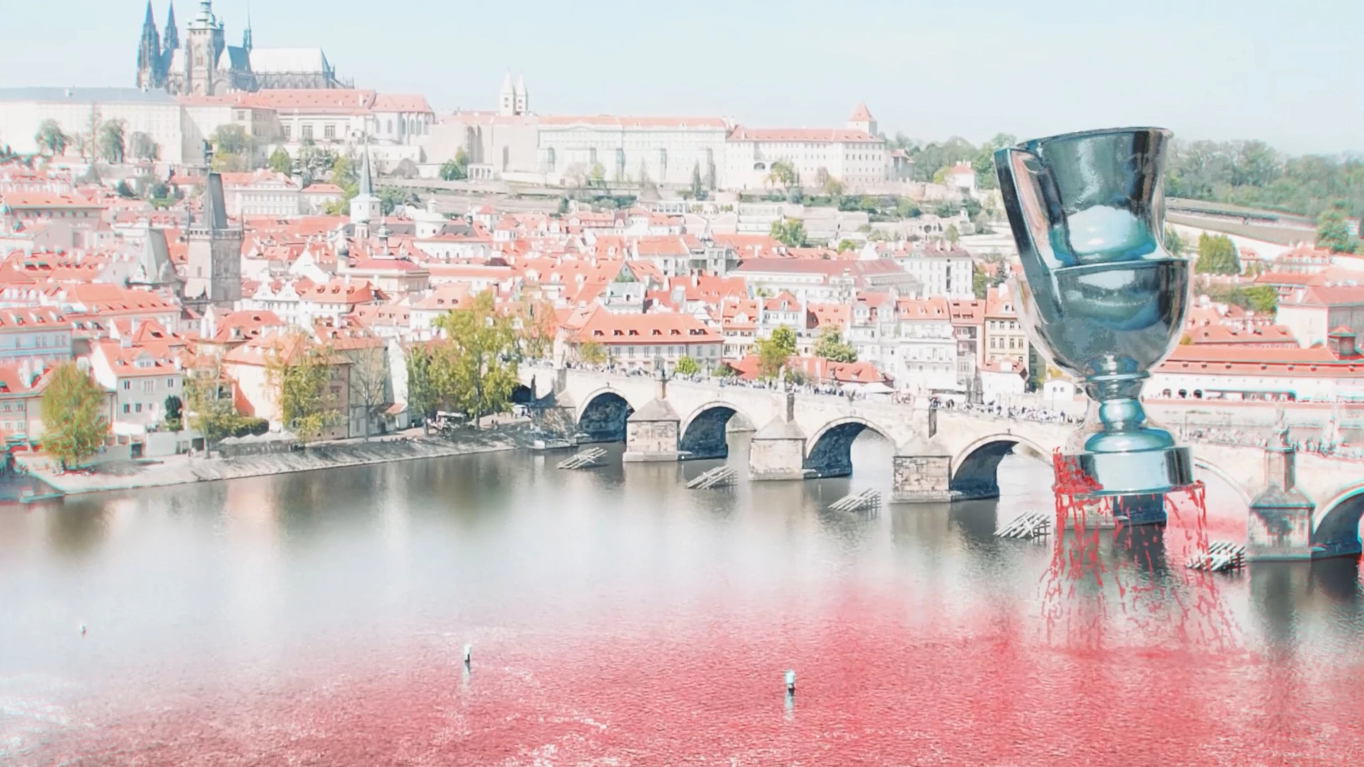 Giant CGI trophy above the Vltava with a red wave spreading across the river.